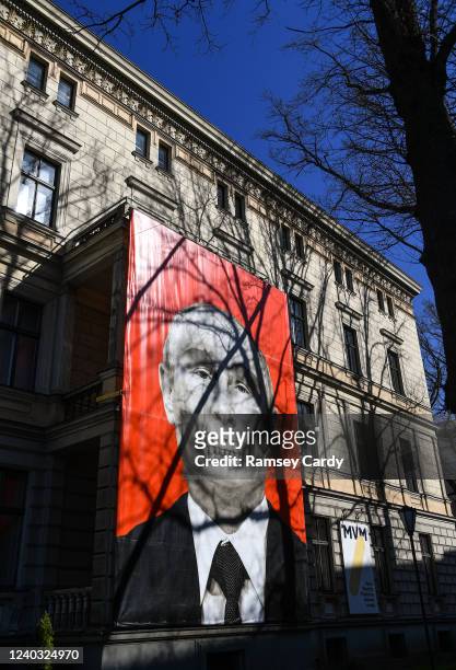 Banner depicting Russian President Vladimir Putin and protesting against the war in Ukraine hangs from a building near the Embassy of Russia on April...