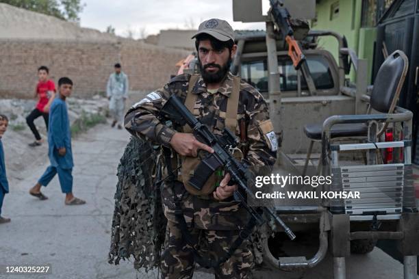 Taliban fighter stands guard near the site of a blast in Kabul on April 29, 2022. - A blast ripped through a Sunni mosque in the Afghan capital on...