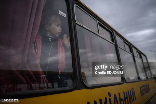 Girl looks out from a bus as families from Russian occupied territories in the Zaporizhzhia region arrive in a humanitarian convoy at a registration...