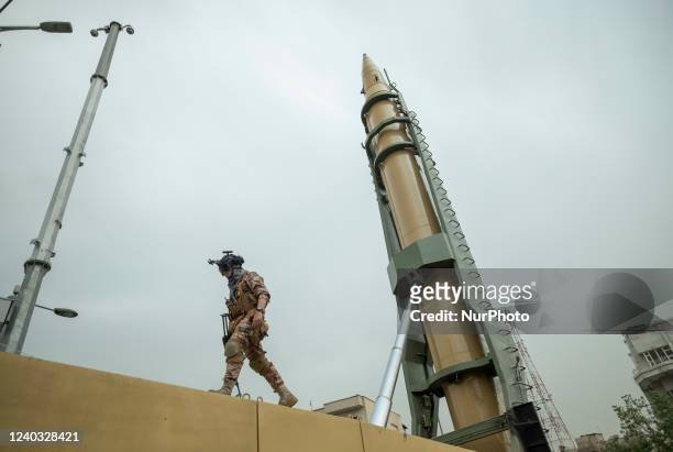An Islamic Revolutionary Guard Corps military personnel walks next to an Iranian Emad Surface-to-Surface missile in downtown Tehran during a rally...