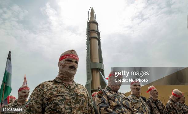 Islamic Revolutionary Guard Corps military personnel parade under an Iranian Kheibar Shekan Ballistic missile in downtown Tehran during a rally...