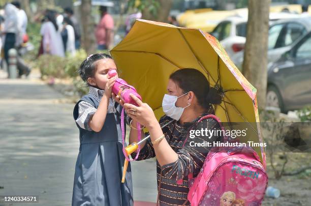 Parent with her ward after the school on a hot summer day at Mandi House area on April 29, 2022 in New Delhi, India. For the second consecutive day,...