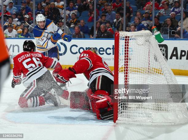 Tage Thompson of the Buffalo Sabres scores a third period goal against Erik Gustafsson and Collin Delia of the Chicago Blackhawks during an NHL game...