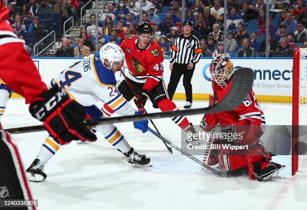 Dylan Cozens of the Buffalo Sabres is defended by Collin Delia and Alex Vlasic of the Chicago Blackhawks during an NHL game on April 29, 2022 at...