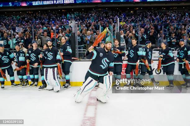 Philipp Grubauer of the Seattle Kraken looks to throw a stuffed salmon to fans as a part of Fan Appreciation Night following the 3-0 win against the...