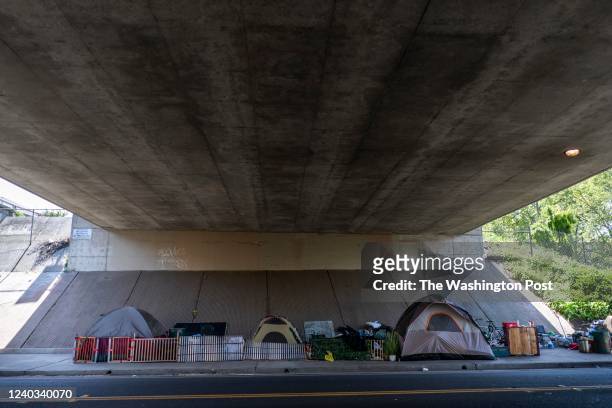 Homeless encampment of tents neatly sit underneath the I-5 freeway in Sacramento, California Sunday April 3, 2022.
