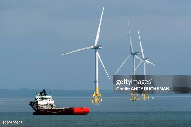 Ferry navigates past wind turbines off the coast of Aberdeen in the North East of Scotland, on April 29, 2022.