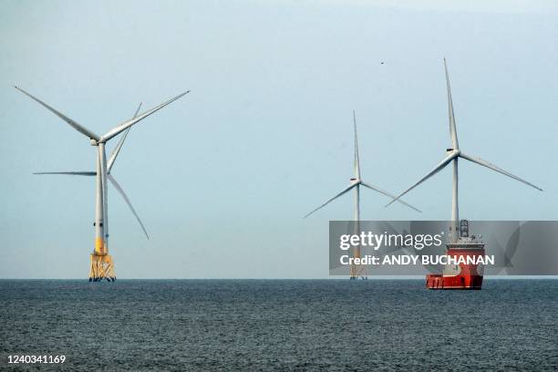 Ferry navigates past wind turbines off the coast of Aberdeen in the North East of Scotland, on April 29, 2022.