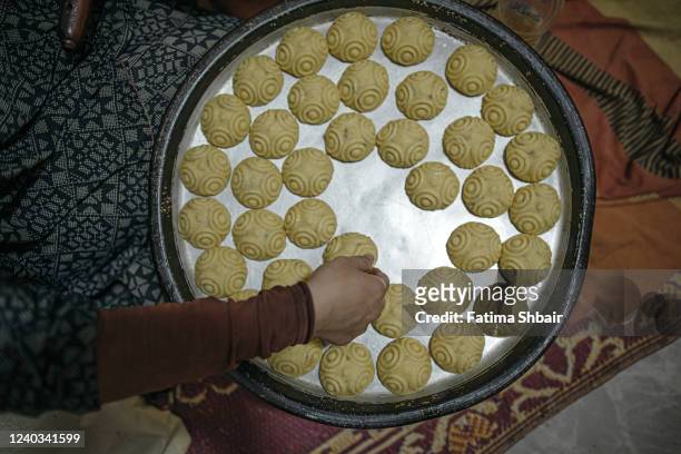 Palestinian women make traditional date-filled cookies in preparation for the Eid al-Fitr holiday at their shop in the old Gaza city on April 29,...