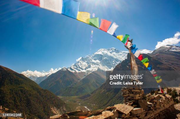 The Annapurna range behind prayer flags as seen from the Annapurna Circuit, Nepal. Climbing to 5,416 meters, the Annapurna Circuit is one of the most...
