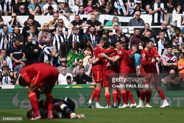 Liverpool's Guinean midfielder Naby Keita celebrates with teammates in front of Newcastle United's Swiss defender Fabian Schar reacting on the pitch,...