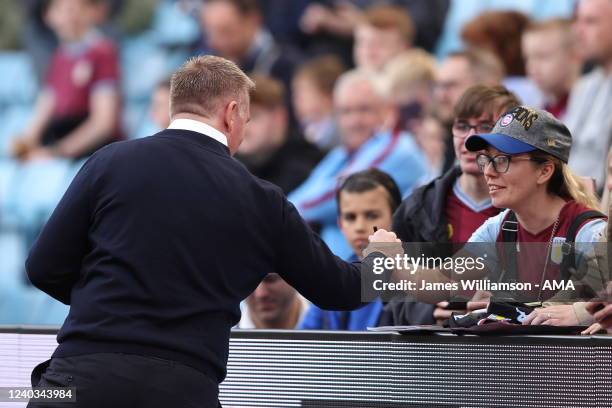 Dean Smith the manager / head coach of Norwich City signs an autograph for a fan of Aston Villa during the Premier League match between Aston Villa...