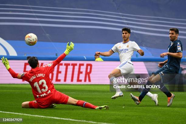 Real Madrid's Spanish midfielder Marco Asensio kicks the ball and scores a goal past Espanyol's Spanish goalkeeper Diego Lopez during the Spanish...