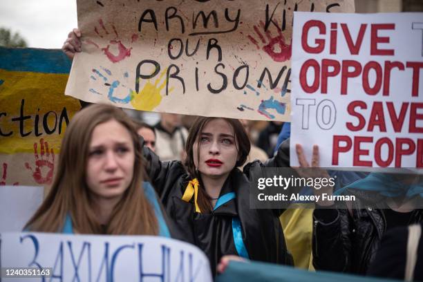 Olha whose fiancé serves in the Azov battalion in Mariupol, cries as she holds a banner saying, «Russian Army Kills Our Prisoners», during the...