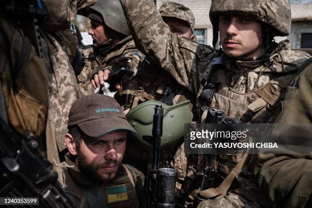 Ukrainian soliders ride in the back of a truck to a resting place after fighting on the front line for two months near Kramatorsk, eastern Ukraine on...