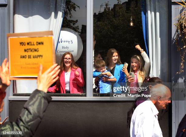 Protester holds a sign quoting WEF's Klaus Schwab 'You Will own Nothing and be Happy' cheered on by youngsters as demonstrators march towards...