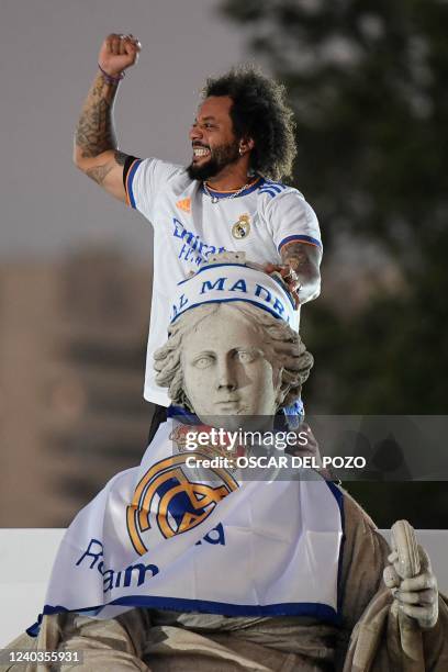 Real Madrid's Brazilian defender Marcelo gestures on top of a statue on the Plaza Cibeles square in Madrid, after Real Madrid CF won the Spanish...