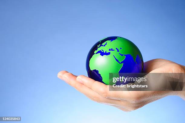 green globe in hand - world at your fingertips stockfoto's en -beelden