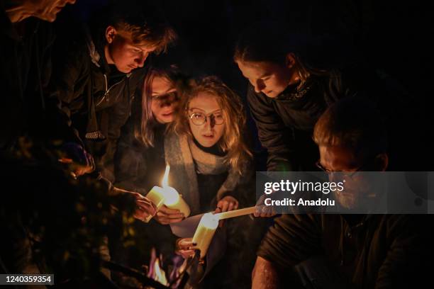 People wear flower crowns and hold candles as they stand around a fireplace during the Beltane celebrations in Krakow, Poland on April 30, 2022....