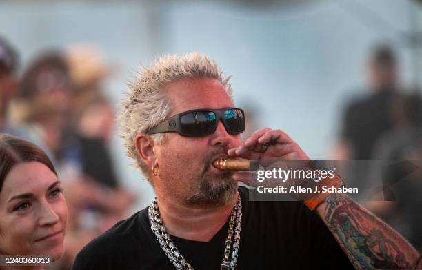 Guy Fieri, chef and host of Food Network's "Diners, DriveIns and Dives," and hosts the Stagecoach Smokehouse, watches Midland perform at sunset on...