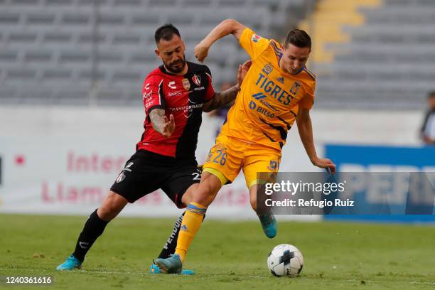 Víctor Aguilera of Atlas fights for the ball with Florian Thauvin of Tigres during the 17th round match between Atlas and Tigres UANL as part of the...