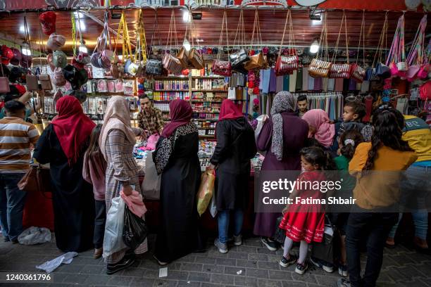 People shop in a market ahead of the Eid al-Fitr holiday in Jabalia refugee camp, north of Gaza City on April 30, 2022 in Gaza City, Gaza....