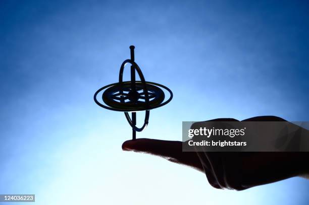 spinning gyroscope in hand - gyroscope stock pictures, royalty-free photos & images