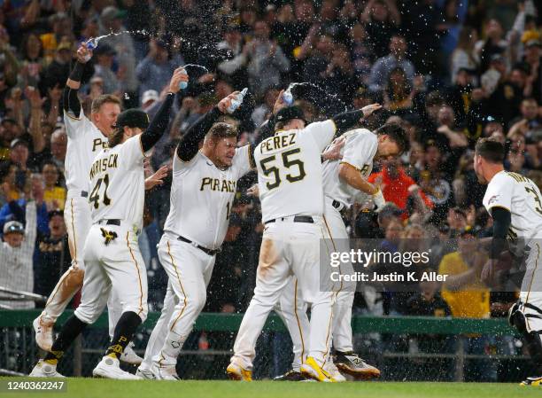 Bryan Reynolds of the Pittsburgh Pirates celebrates with teammates after driving in the winning run in the tenth inning against the San Diego Padres...