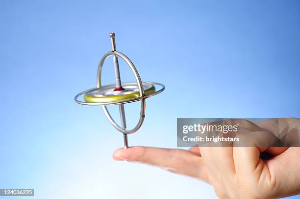 spinning gyroscope in hand - gyroscope stock pictures, royalty-free photos & images
