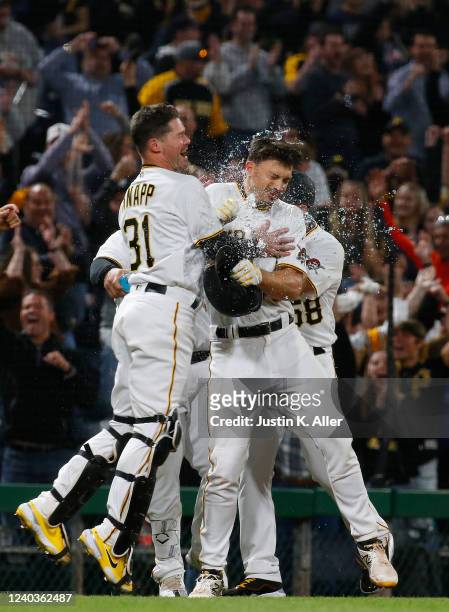 Bryan Reynolds of the Pittsburgh Pirates celebrates with teammates after driving in the winning run in the tenth inning against the San Diego Padres...