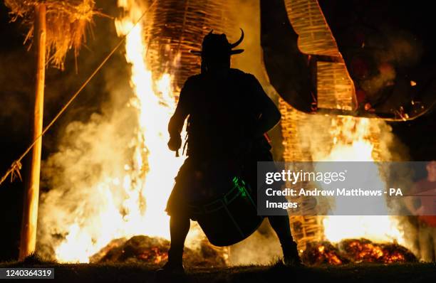 Member of the Pentacle Drummers performs in front of a burning wicker man during the Beltain Festival at Butser Ancient Farm, in Waterlooville,...