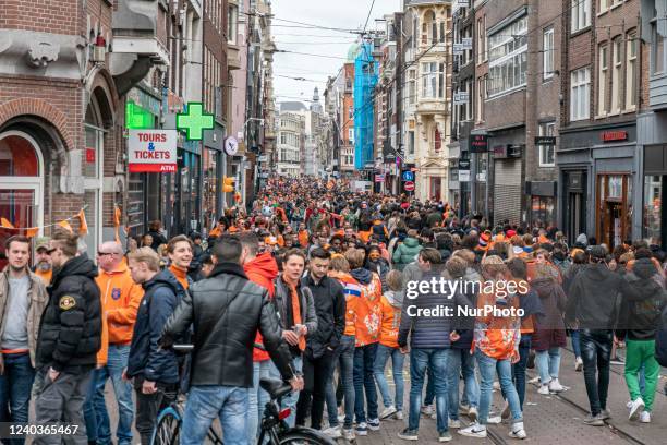 Crowds of people wearing mainly orange clothes and having the Dutch flag as seen in the streets of Amsterdam while The Netherlands celebrates King's...