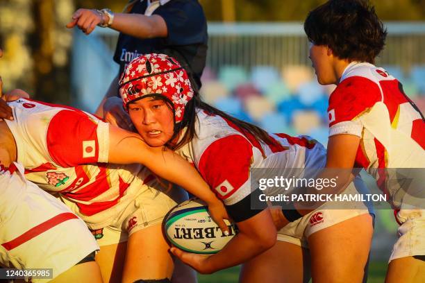 Japan's Makoto Lavemai carries the ball during the women's rugby Test match between Fiji and Japan on the Gold Coast on May 1, 2022. - -- IMAGE...