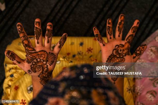 Girl gets her hand decorated with henna at a market area ahead of Eid al-Fitr, which marks the end of the Muslim's holy festival of Ramadan in...