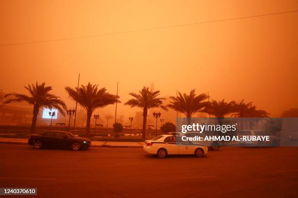 Vehicles drive along a road during a severe dust storm in Iraq's capital Baghdad on May 1, 2022. - Flights were grounded today due to poor visibility...