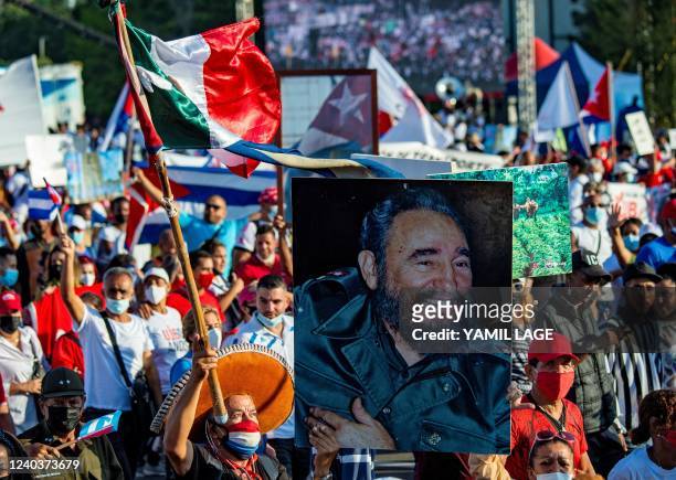 Demonstrator carries a poster with an image of late Cuban president Fidel Castro during the commemoration of May Day to mark the international day of...