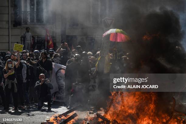 Protesters gather near a fire in the road during clashes with police on the sidelines of the annual May Day rally, marking International Workers'...