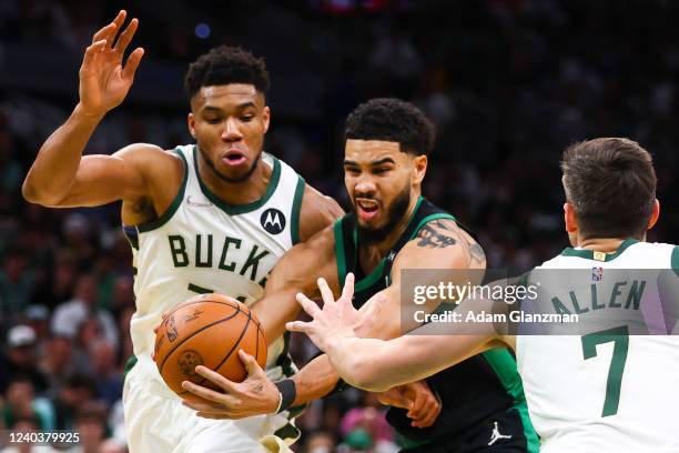 Jayson Tatum of the Boston Celtics drives to the basket past Giannis Antetokounmpo and Grayson Allen of the Milwaukee Bucks during Game One of the...