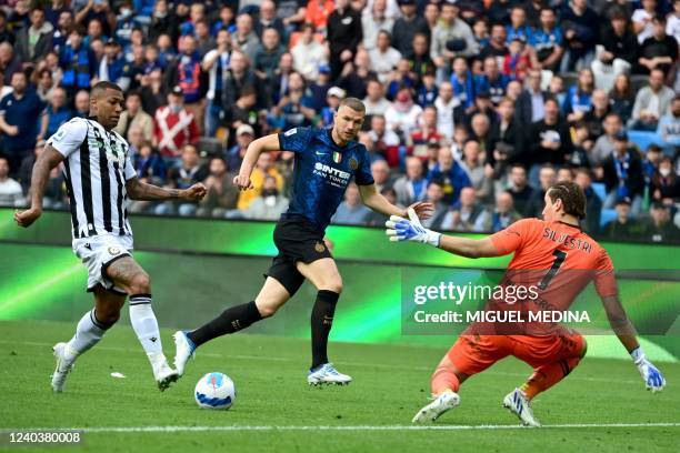 Udinese's Brazilian defender Rodrigo faces Udinese's Italian goalkeeper Marco Silvestri past Inter Milan's Bosnian forward Edin Dzeko during the...