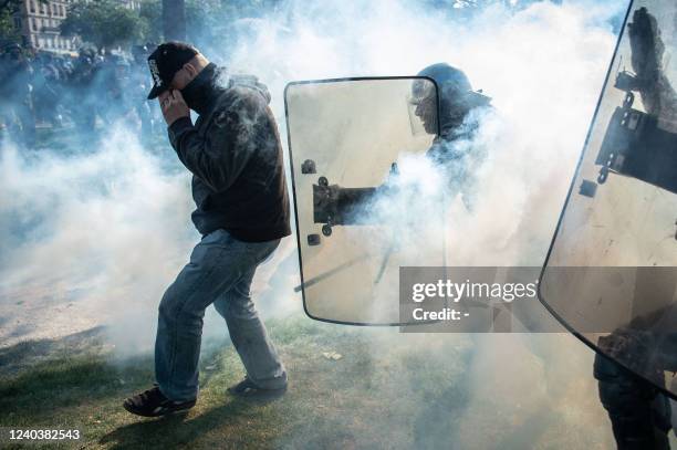 Police officer clashes with a protesters in tear gas smoke on the sidelines of the annual May Day rally, marking International Workers' Day, in Paris...