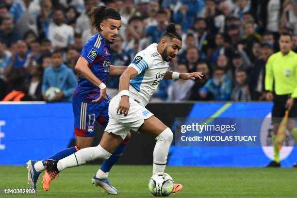 Lyon's French defender Malo Gusto challenges Marseille's French midfielder Dimitri Payet during the French L1 football match between Olympique...