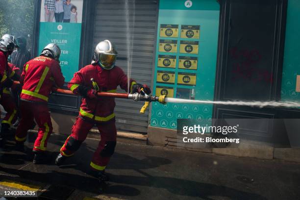Firefighters extinguish a fire during traditional May 1 holiday demonstrations on International Workers Day in Paris, France, on Sunday, May 1, 2022....