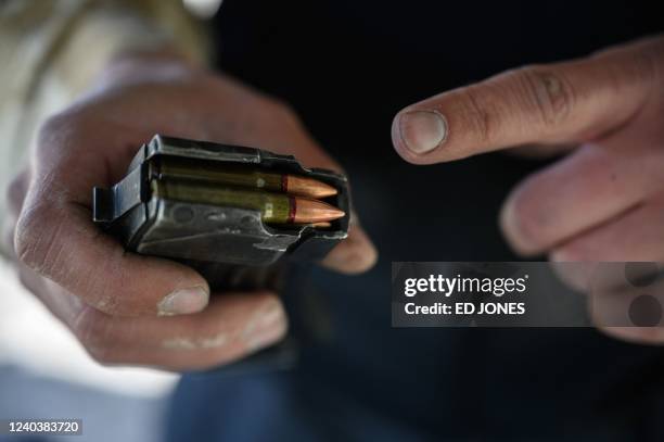 Vadim Mernichenko loads a magazine with rifle ammunition as he prepares to test a ballistic plate that he makes, at a shooting range in Zaporizhzhia...