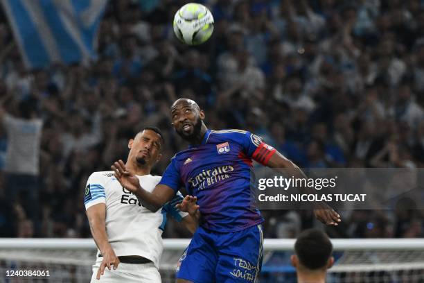 Marseille's French defender William Saliba heads the ball with Lyon's French forward Moussa Dembele during the French L1 football match between...