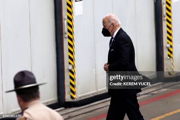 President Joe Biden wears a protective face mask prior to boarding Air Force One at Minneapolis-Saint Paul International Airport in Minneapolis,...