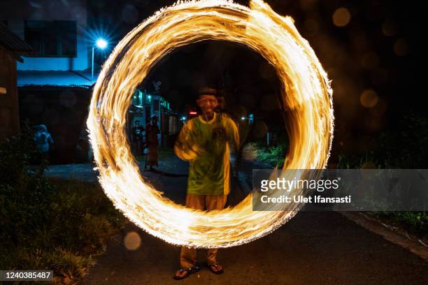 An Indonesian Muslim man plays with a fire stick during a parade as Muslims celebrate Eid Al-Fitr to mark the end of Ramadan, the holy month of...