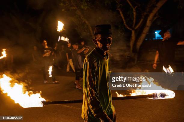 An Indonesian Muslim man plays with a fire stick during a parade as Muslims celebrate Eid Al-Fitr to mark the end of Ramadan, the holy month of...