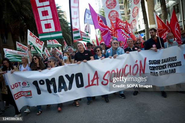 Protesters are seen holding union and labor flags and a large banner as they take part during the Labour Day demonstration. Thousands of people...