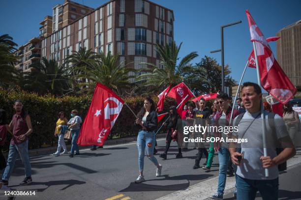 Protesters are seen holding communist party flags as they take part during the Labour Day demonstration. Thousands of people called by the General...