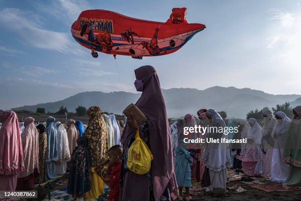 Woman holds balloon as Indonesian Muslims perform Eid Al-Fitr prayer on 'sea of sands' at Parangkusumo beach on May 02, 2022 in Yogyakarta,...